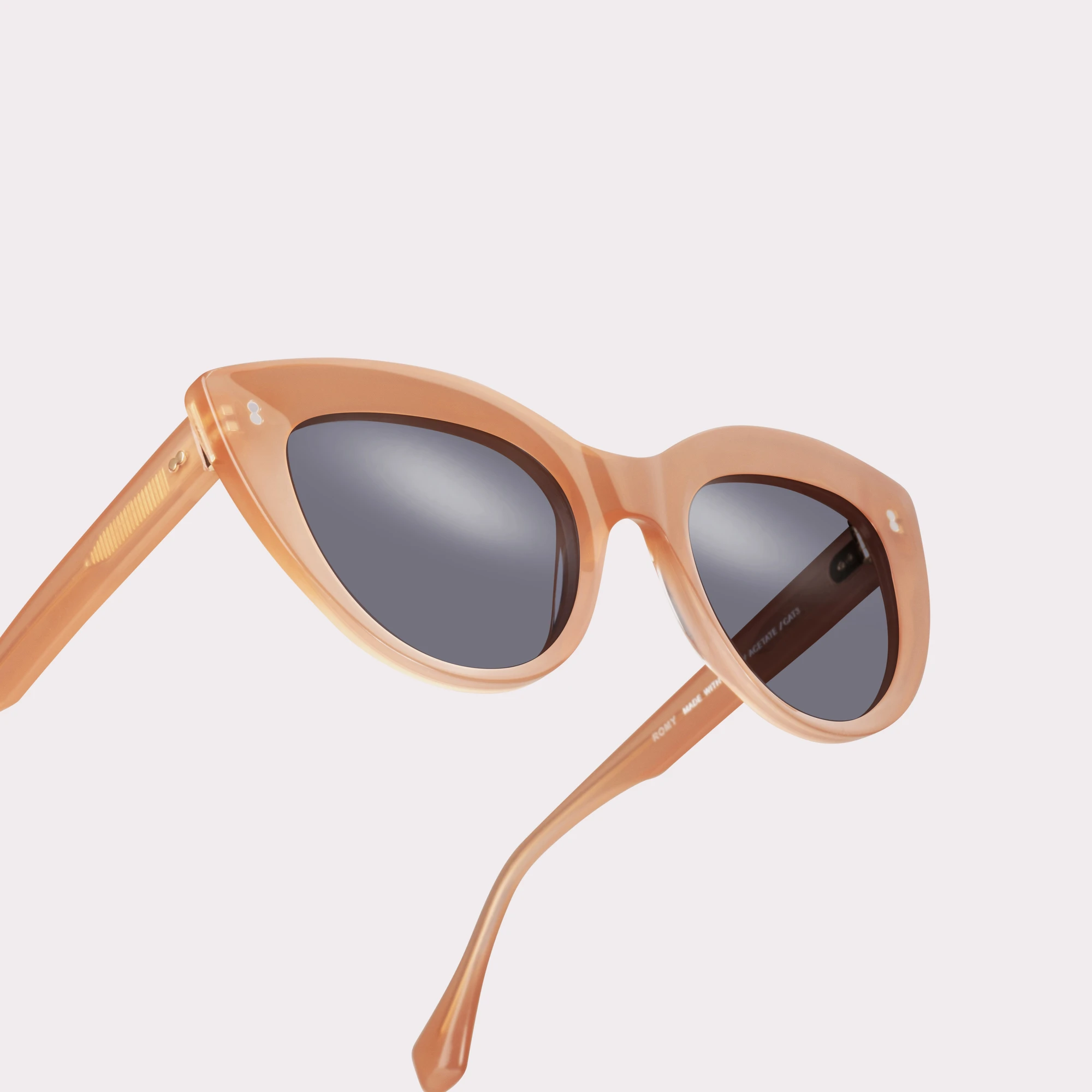 A pair of Romy Milky Pink Sunglasses in a macro view