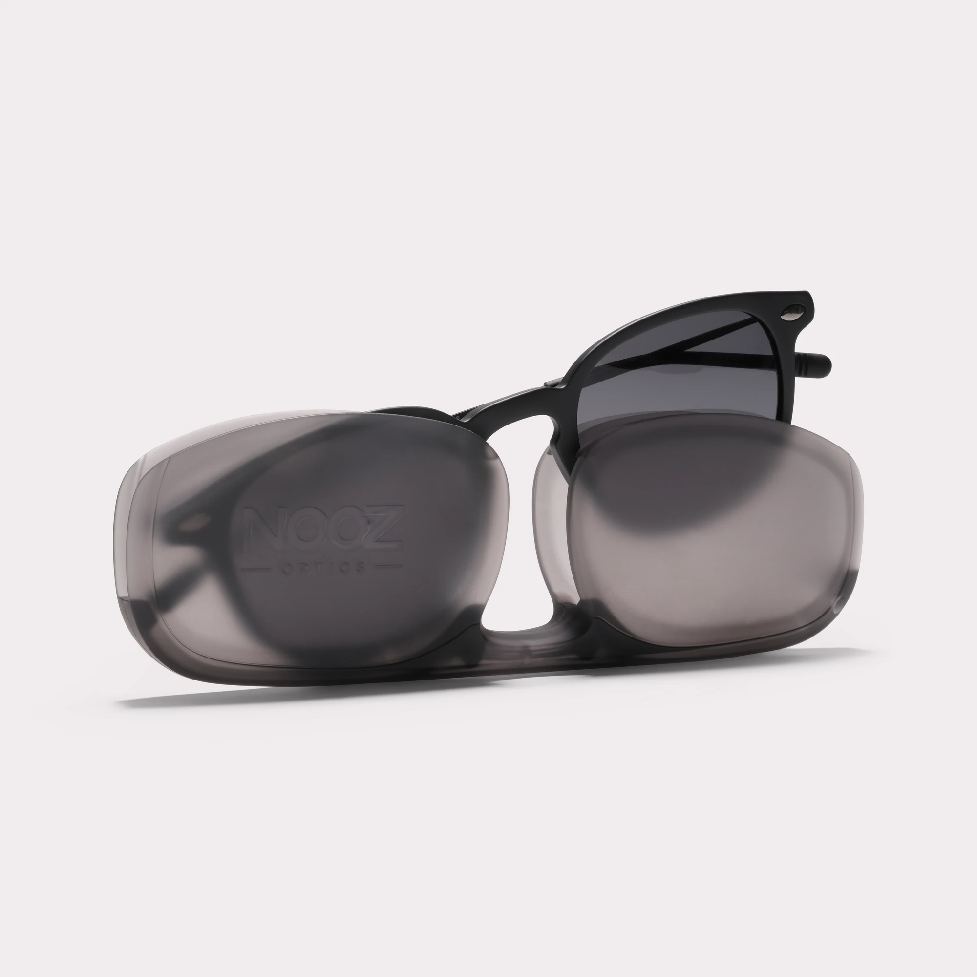 A pair of Alma Black Sunglasses coming out of its case