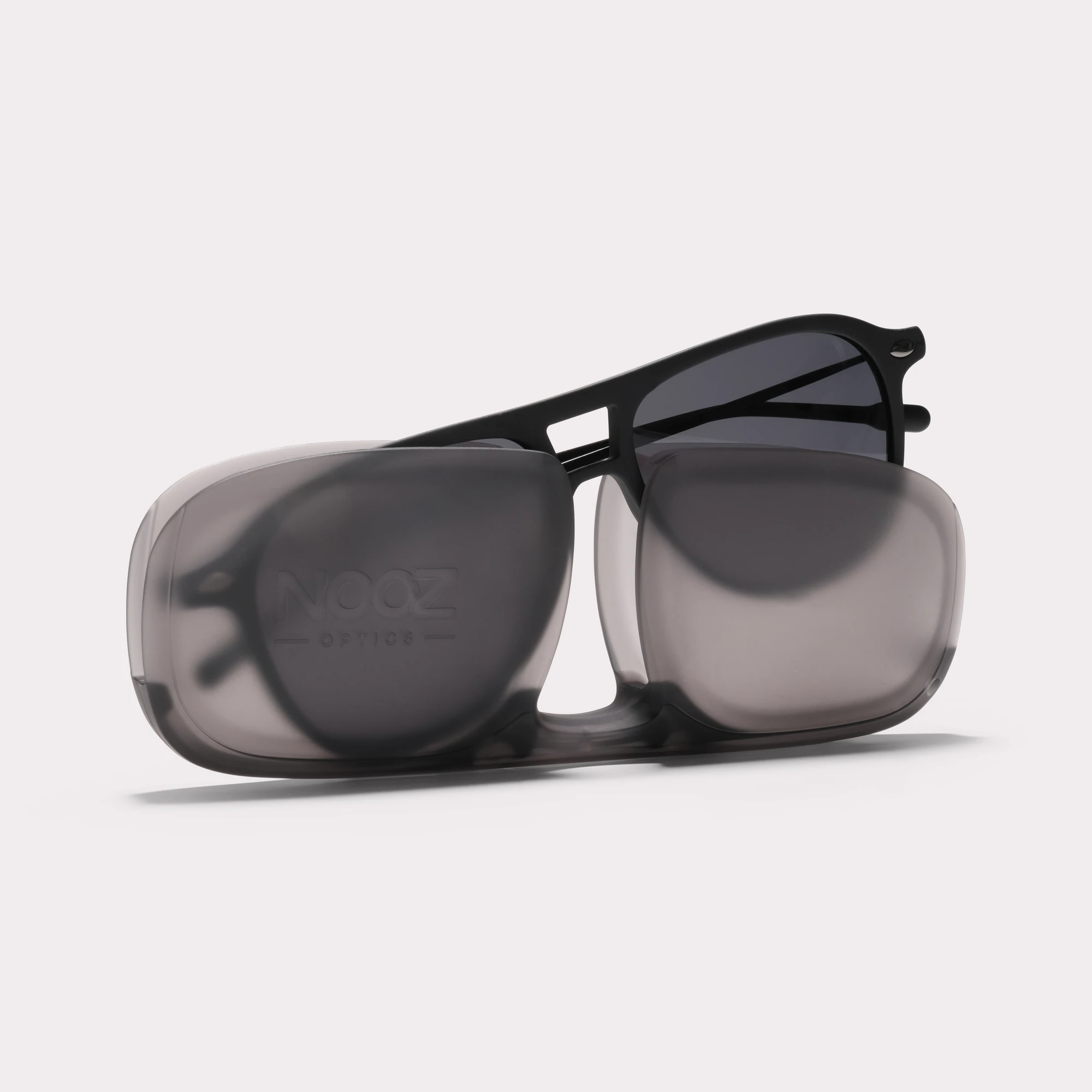 A pair of Fly Black Sunglasses coming out of its case