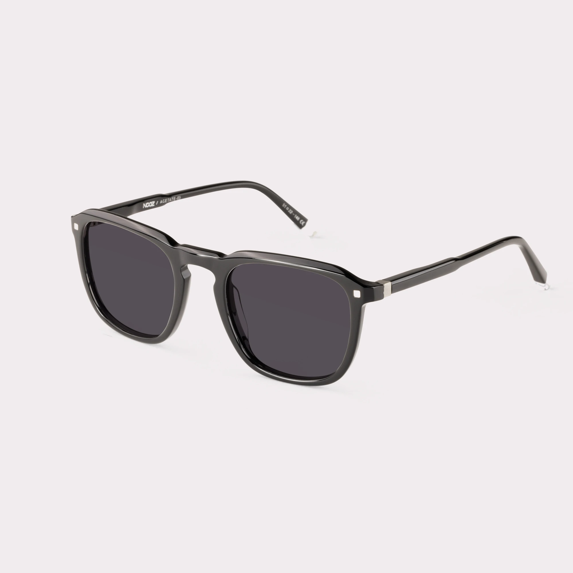 A pair of Carmen Black Sunglasses  seen from the side