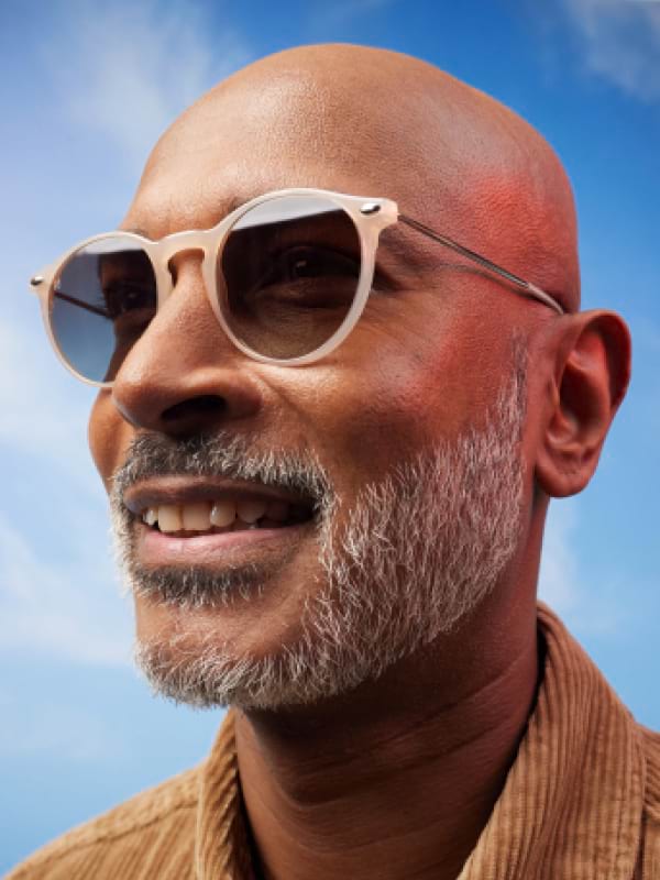 Sunglasses worn by a smiling blonde woman in the sun