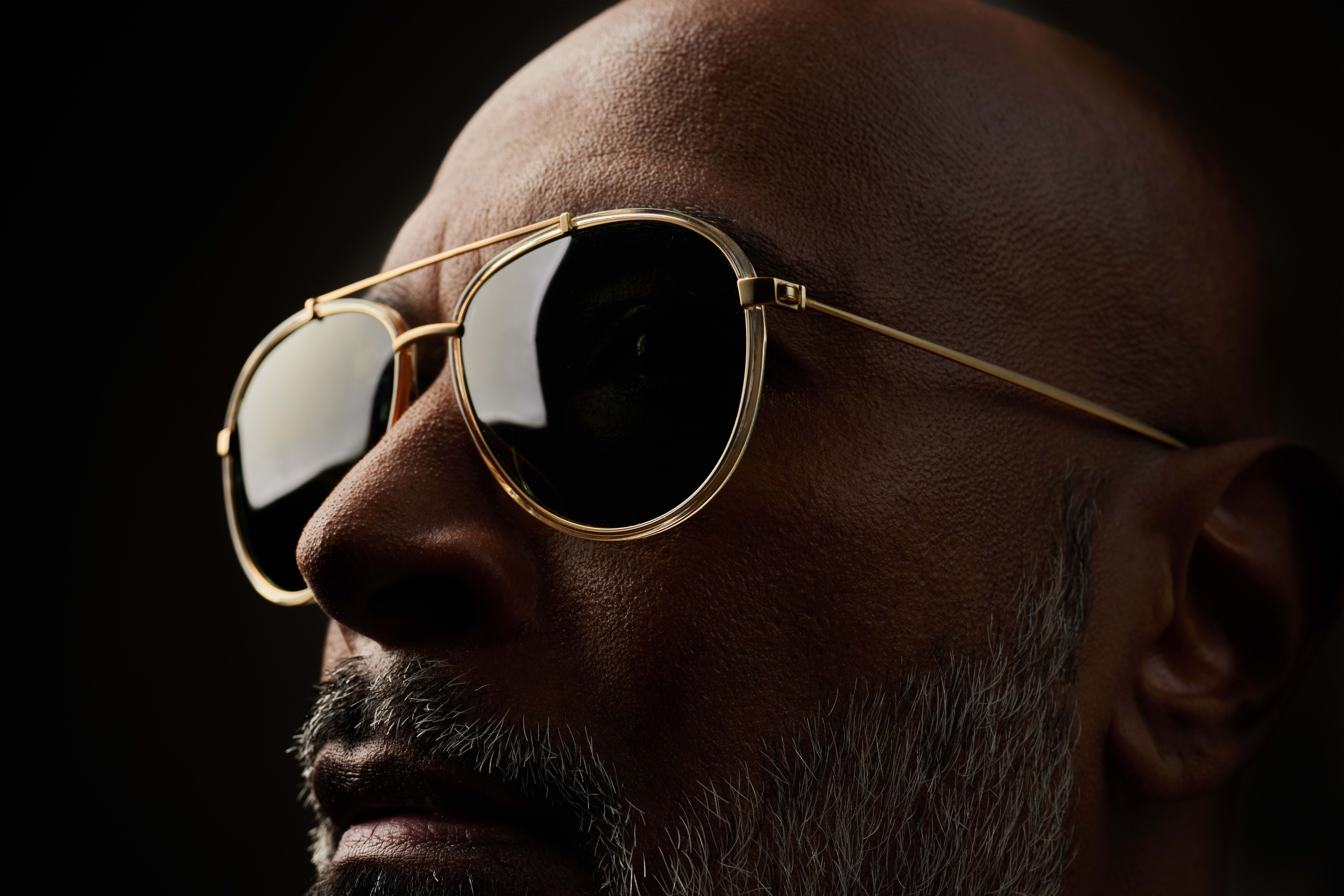 a person holding a pair of orange sunglasses.